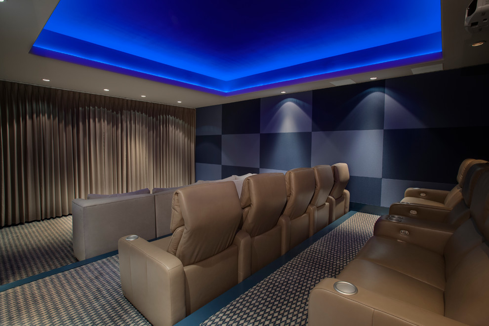 Imagen de cine en casa cerrado actual grande con paredes azules, moqueta y pantalla de proyección