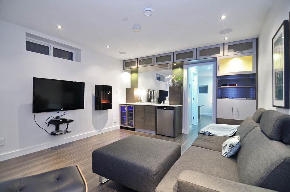 Diseño de cine en casa abierto contemporáneo con paredes blancas, suelo laminado y televisor colgado en la pared