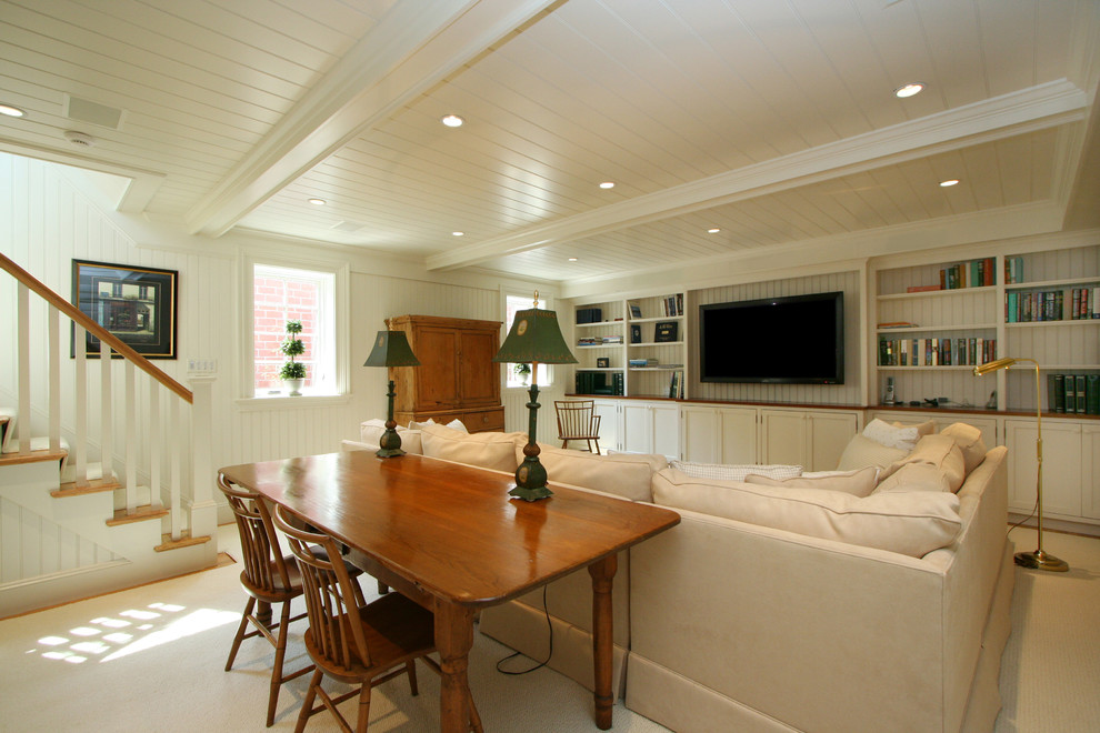 Modelo de cine en casa abierto costero grande con paredes blancas, suelo de madera clara y televisor colgado en la pared