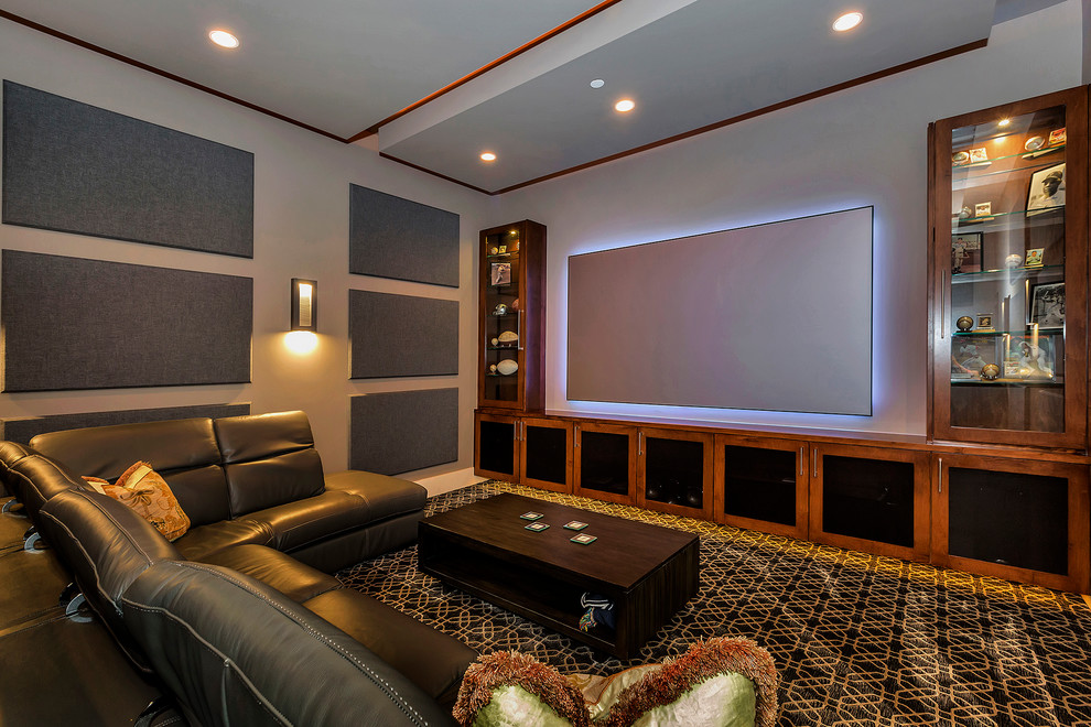 Modern inredning av ett avskild hemmabio, med grå väggar, heltäckningsmatta, en väggmonterad TV och flerfärgat golv
