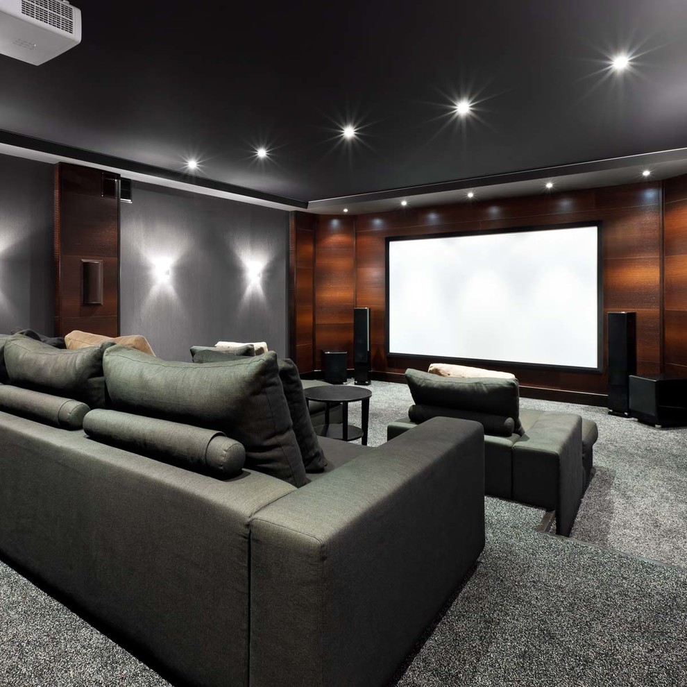 Diseño de cine en casa cerrado actual de tamaño medio con paredes grises, moqueta y pantalla de proyección