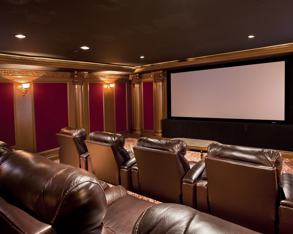 This is an example of a large classic enclosed home cinema in Boston with red walls, carpet and a projector screen.