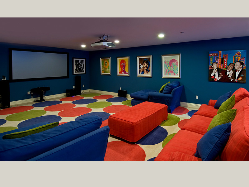 Imagen de cine en casa cerrado actual extra grande con paredes azules, moqueta, pantalla de proyección y suelo multicolor