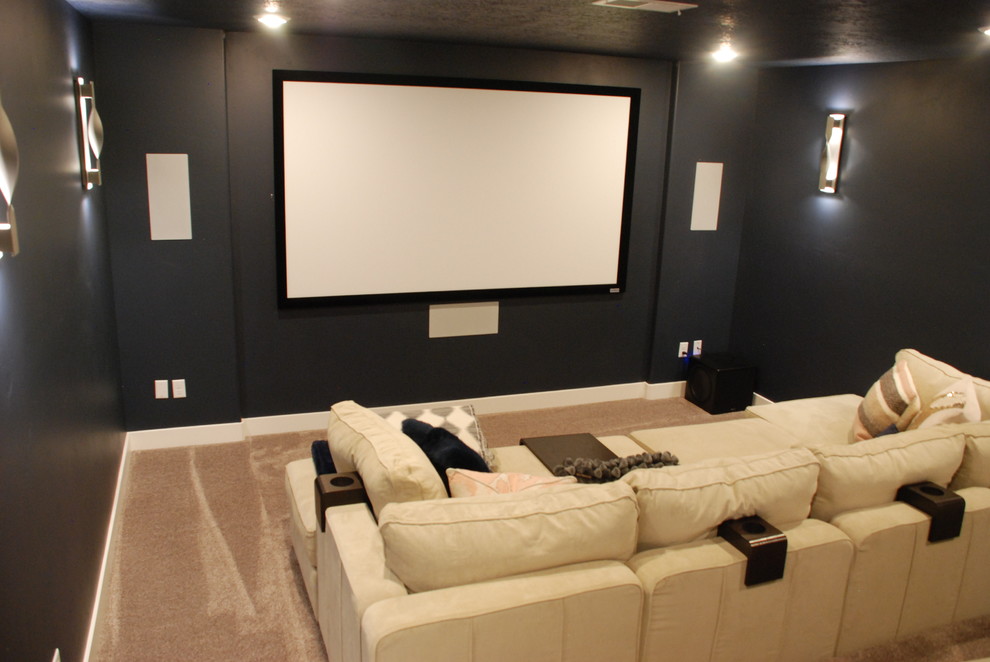 Idee per un home theatre classico di medie dimensioni e chiuso con pareti nere, moquette, schermo di proiezione e pavimento beige