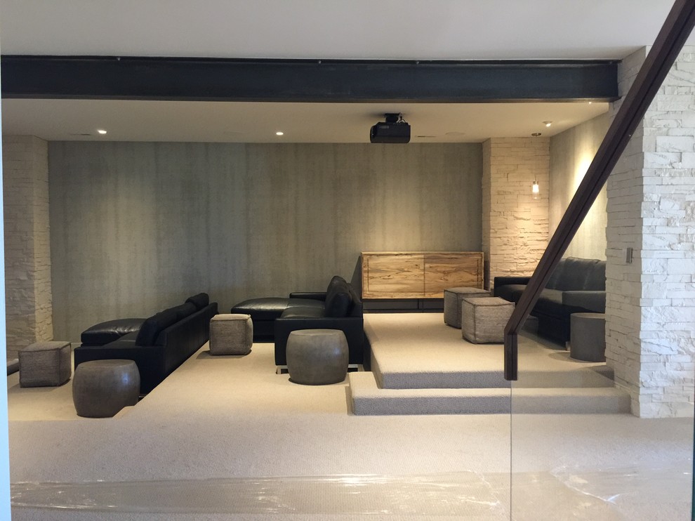 На фото: огромный открытый домашний кинотеатр в стиле модернизм с белыми стенами, ковровым покрытием, телевизором на стене и серым полом