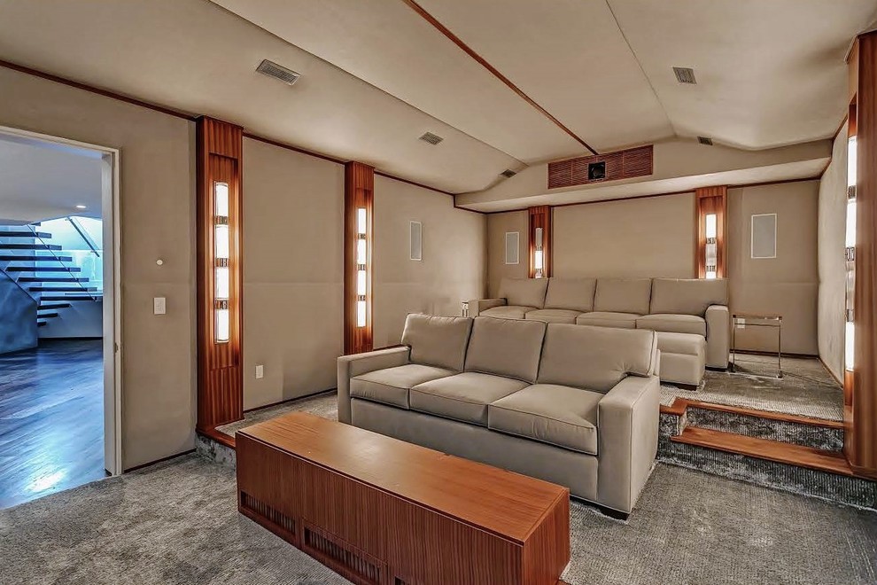 Large contemporary enclosed home cinema in Toronto with beige walls, carpet, a projector screen and grey floors.