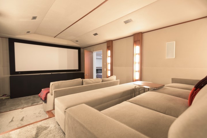 Esempio di un grande home theatre contemporaneo chiuso con pareti beige, moquette, schermo di proiezione e pavimento grigio
