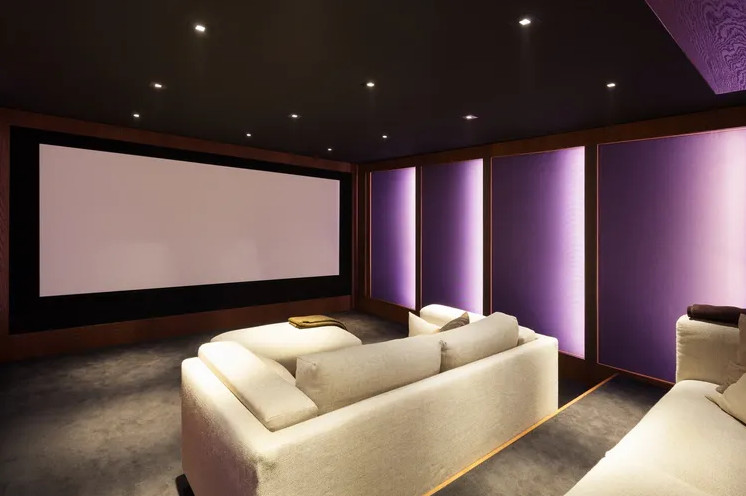 Idee per un grande home theatre minimal chiuso con pareti nere, moquette, schermo di proiezione e pavimento marrone