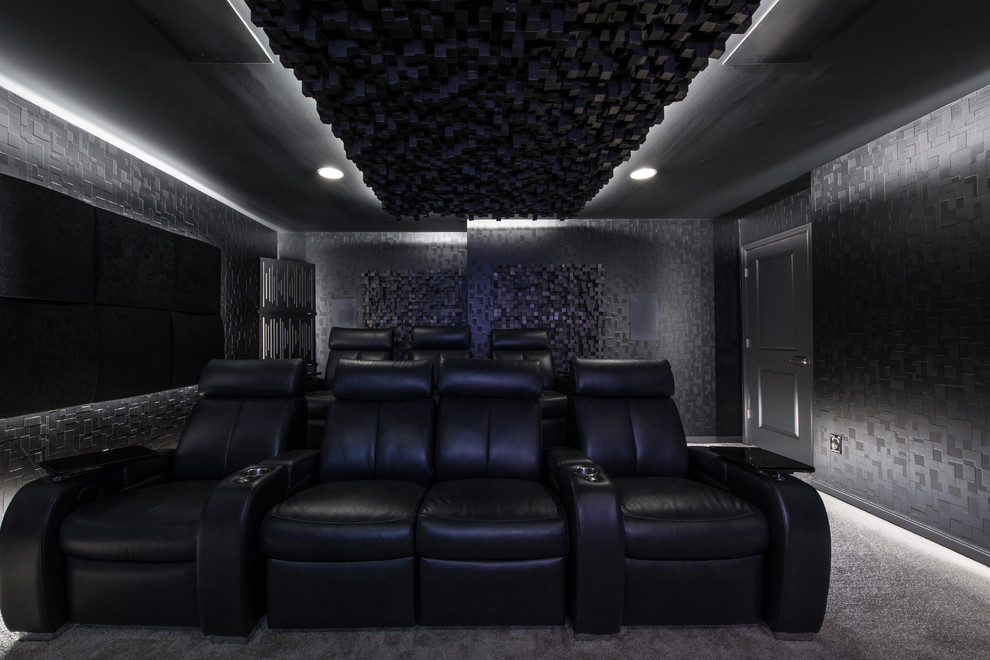 Aménagement d'une salle de cinéma moderne avec un mur noir, moquette, un écran de projection et un sol gris.