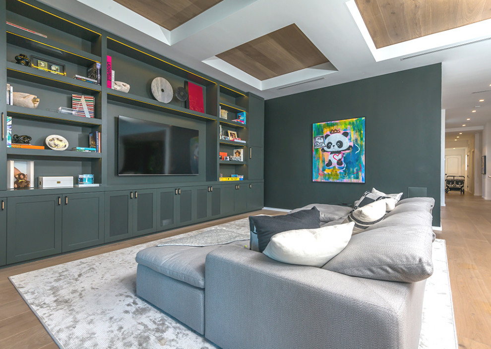 Diseño de cine en casa abierto actual extra grande con paredes verdes, suelo de madera en tonos medios, pared multimedia y suelo marrón