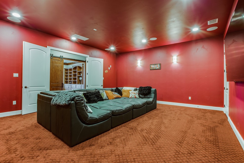 Ejemplo de cine en casa cerrado tradicional renovado extra grande con paredes rojas, moqueta y televisor colgado en la pared