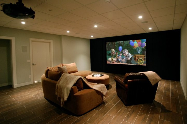 Cette photo montre une salle de cinéma chic de taille moyenne et fermée avec un mur vert, un sol en carrelage de porcelaine, un téléviseur encastré et un sol marron.