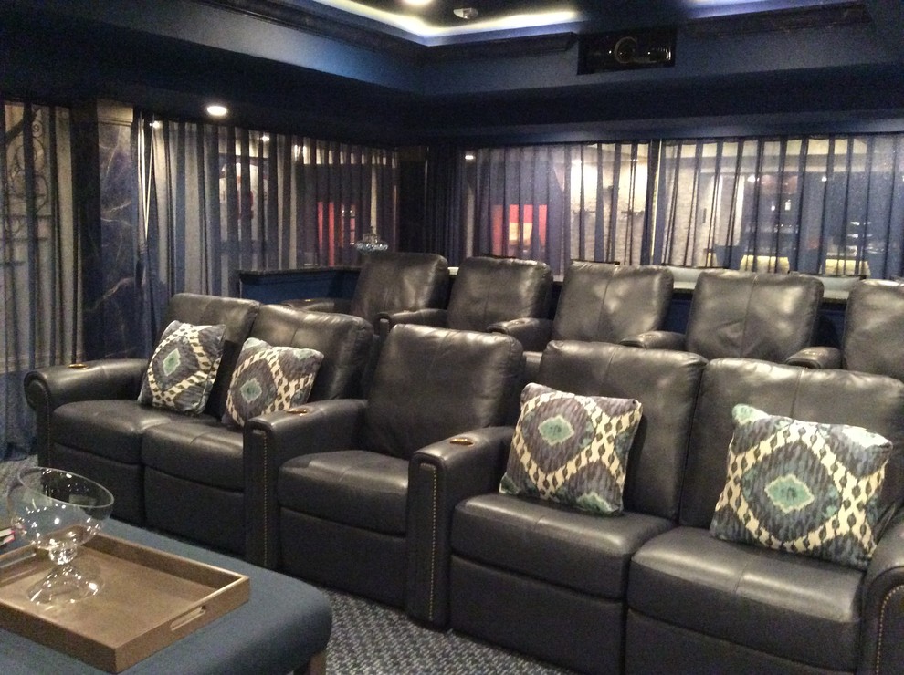 This is an example of a large classic open plan home cinema in New York with blue walls, carpet and a projector screen.