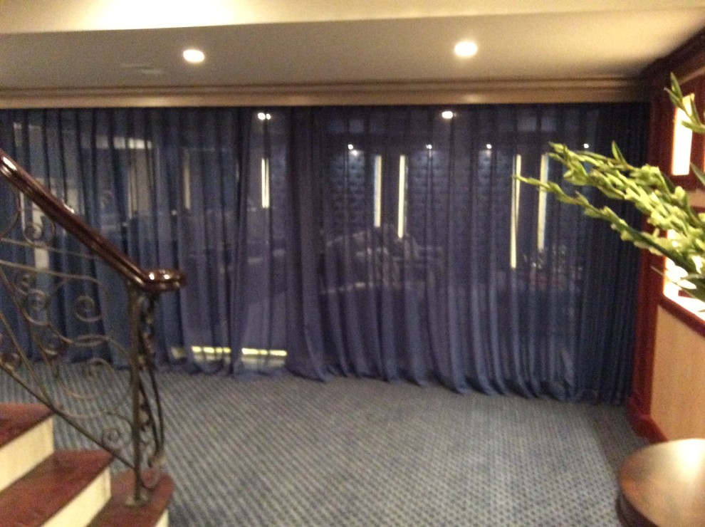 ニューヨークにある広いトランジショナルスタイルのおしゃれなオープンシアタールーム (青い壁、カーペット敷き、プロジェクタースクリーン) の写真