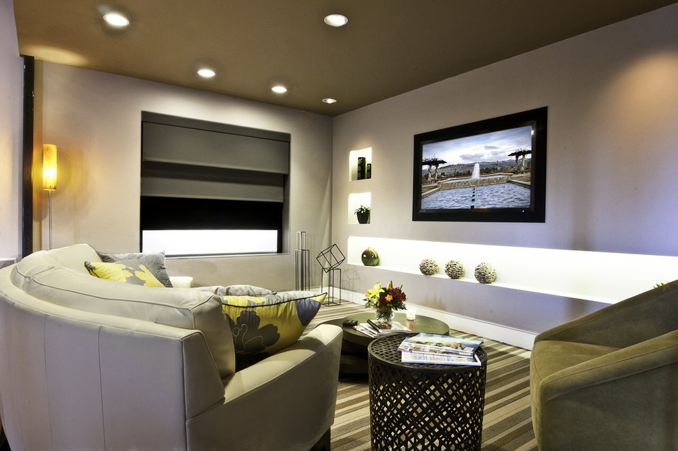 Foto de cine en casa cerrado moderno grande con paredes grises, televisor colgado en la pared, moqueta y suelo verde