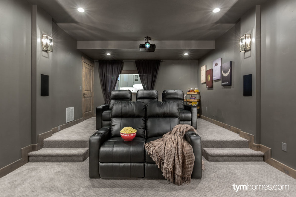 Modelo de cine en casa cerrado clásico de tamaño medio con paredes grises, moqueta y pantalla de proyección