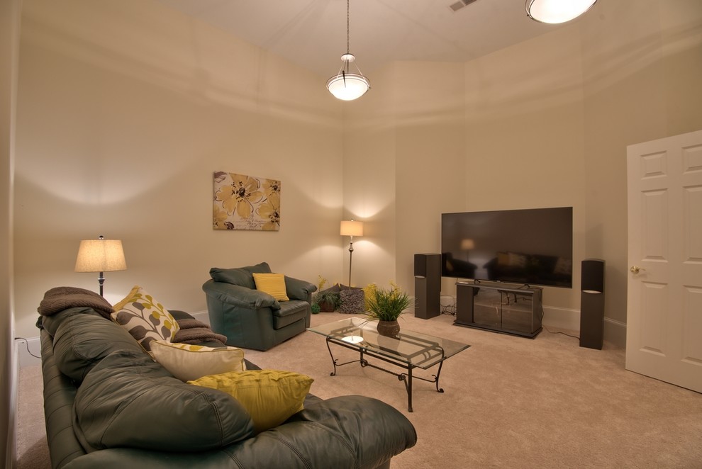 Diseño de cine en casa cerrado tradicional renovado de tamaño medio con paredes beige, moqueta, televisor colgado en la pared y suelo beige