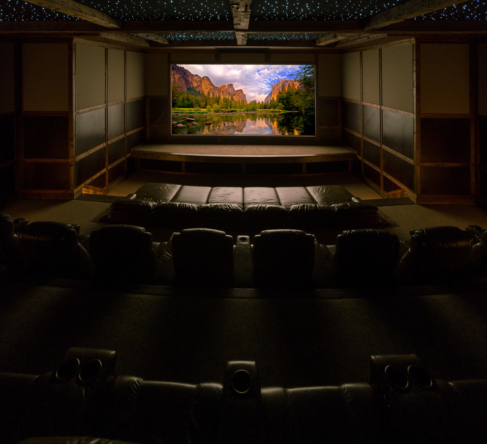 Huge trendy enclosed carpeted home theater photo in Denver with beige walls and a projector screen