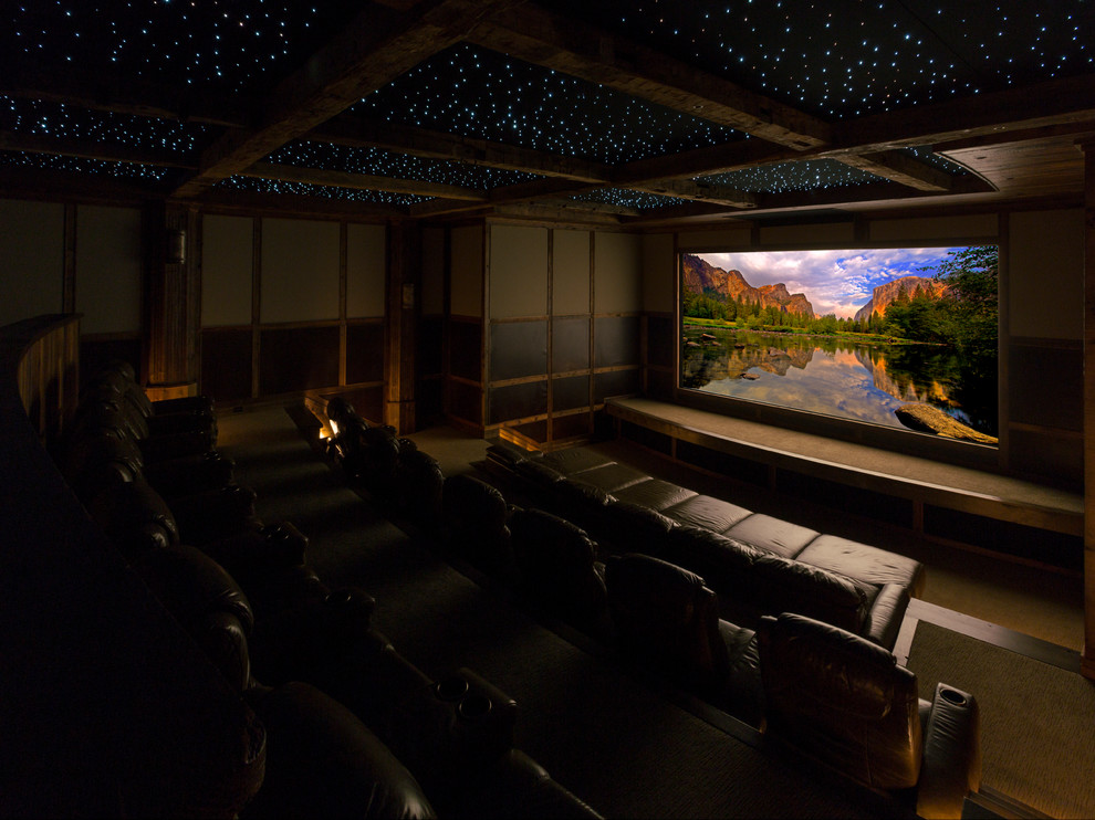 Huge elegant enclosed carpeted home theater photo in Denver with beige walls and a projector screen