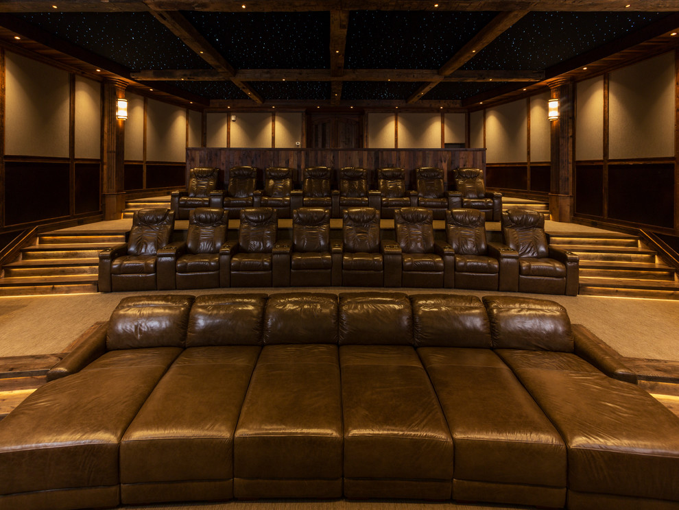 Huge elegant enclosed carpeted home theater photo in Denver with beige walls and a projector screen