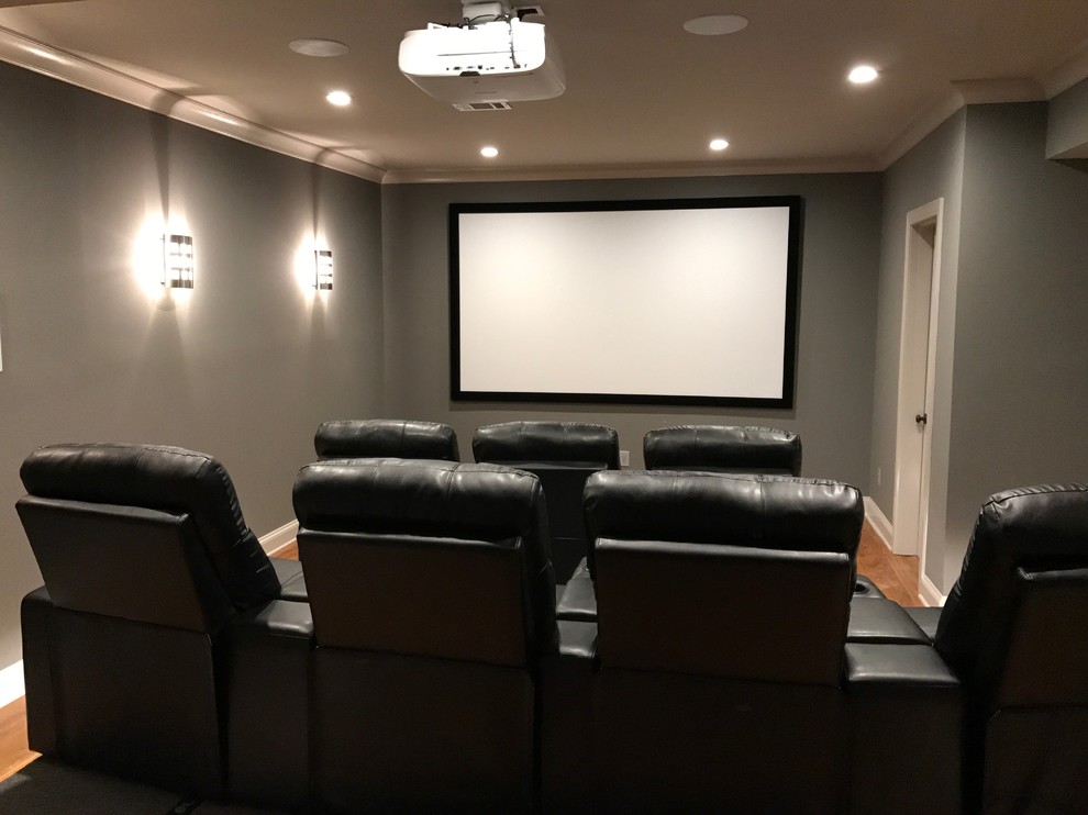 На фото: изолированный домашний кинотеатр среднего размера в классическом стиле с бетонным полом, бежевым полом, серыми стенами и проектором