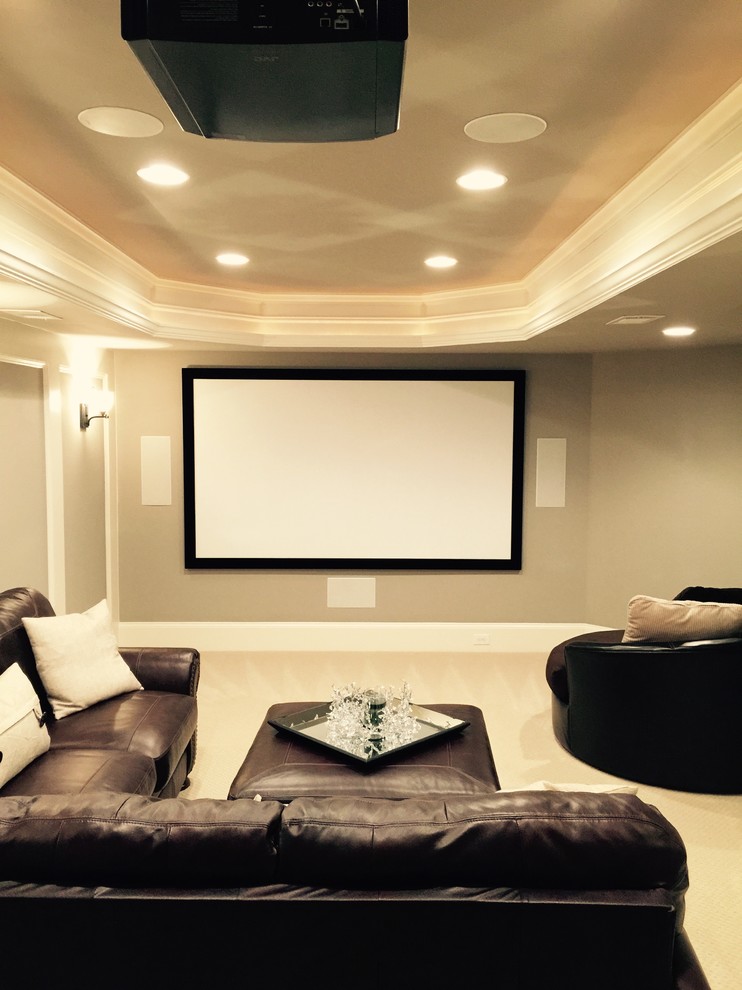 Immagine di un home theatre classico di medie dimensioni e chiuso con pareti beige, moquette, schermo di proiezione e pavimento beige