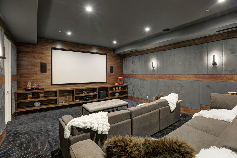 Imagen de cine en casa cerrado actual grande con paredes grises, moqueta, televisor colgado en la pared y suelo negro