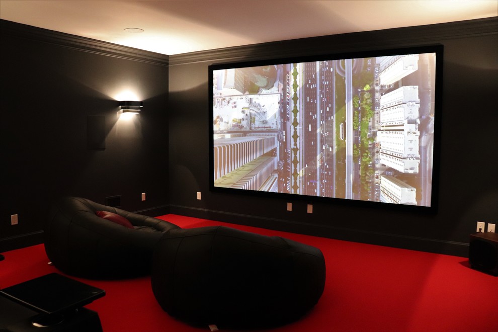 На фото: изолированный домашний кинотеатр среднего размера в современном стиле с черными стенами, ковровым покрытием, проектором и красным полом