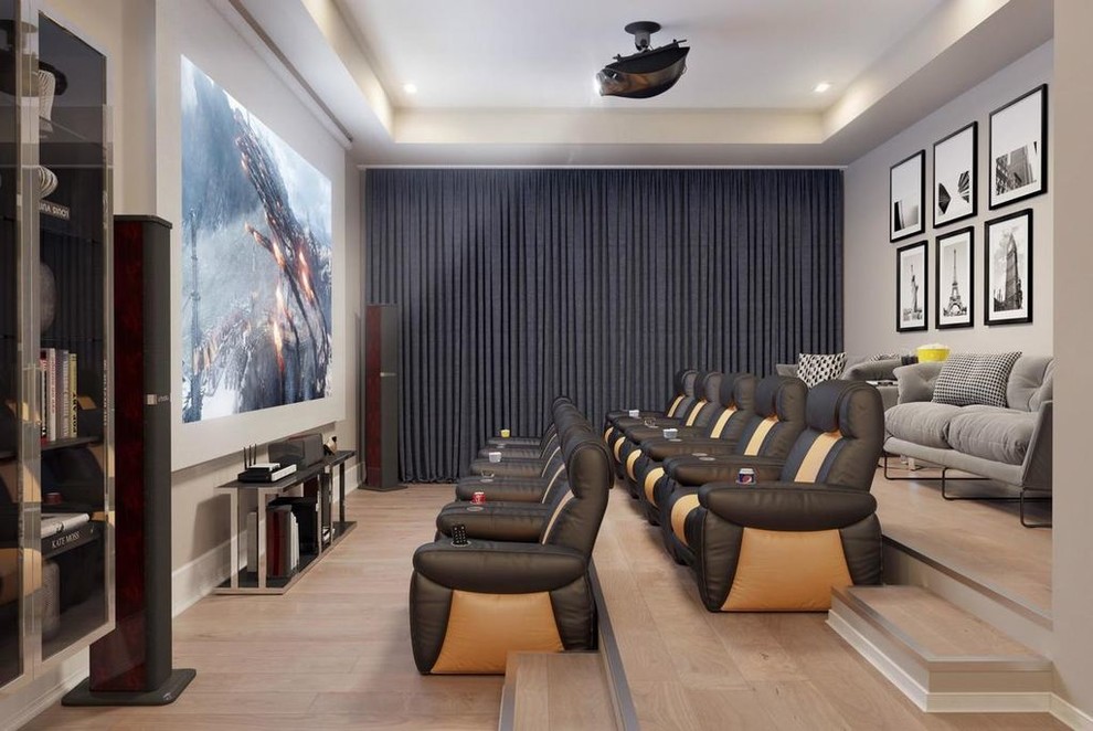 Ejemplo de cine en casa contemporáneo con paredes grises, suelo de madera clara, pantalla de proyección y suelo beige