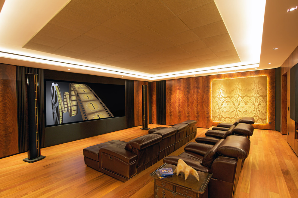 Idées déco pour une grande salle de cinéma contemporaine fermée avec un mur marron, parquet clair, un téléviseur encastré et un sol orange.
