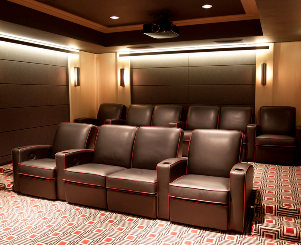На фото: большой изолированный домашний кинотеатр в современном стиле с бежевыми стенами, ковровым покрытием, проектором и разноцветным полом