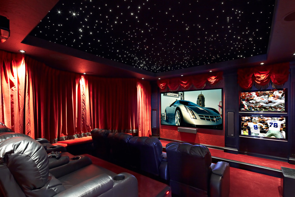 На фото: большой изолированный домашний кинотеатр в средиземноморском стиле с красными стенами, ковровым покрытием, красным полом и проектором с