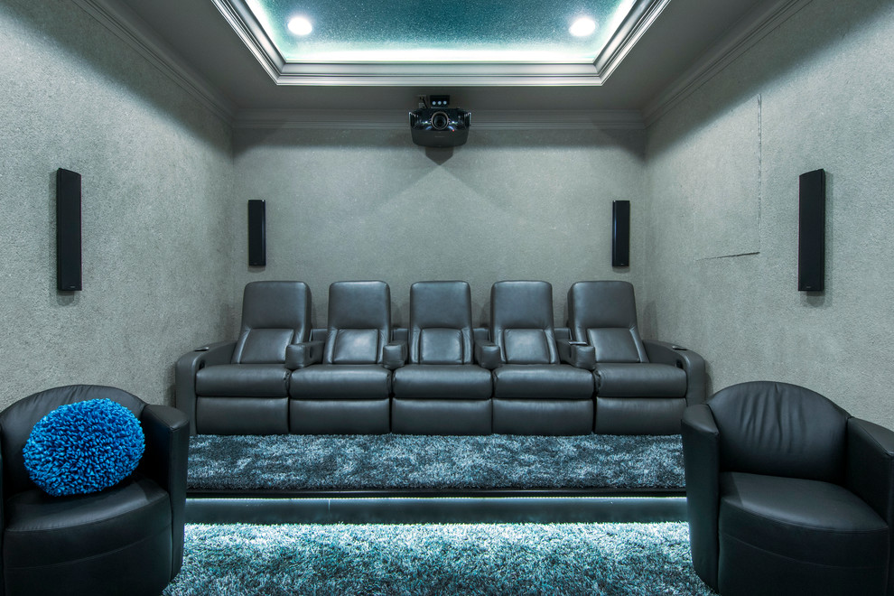 Idée de décoration pour une petite salle de cinéma design fermée avec un mur gris, moquette et un téléviseur fixé au mur.