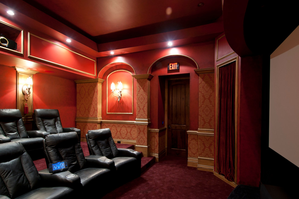 Diseño de cine en casa cerrado tradicional de tamaño medio con paredes rojas, moqueta, pantalla de proyección y suelo rojo
