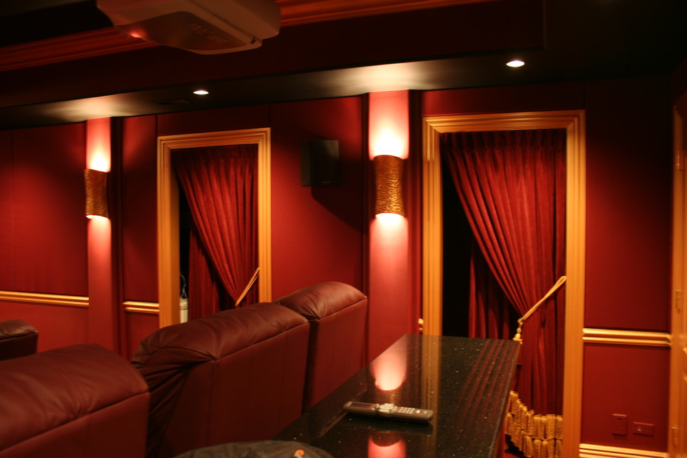 На фото: изолированный домашний кинотеатр в классическом стиле с красными стенами, ковровым покрытием и проектором