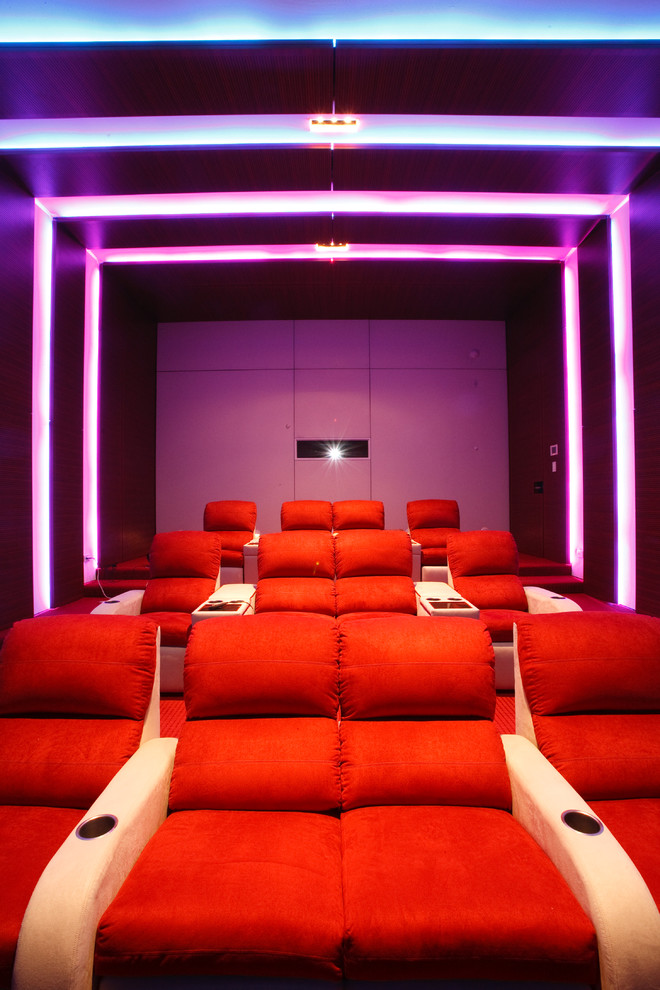 Immagine di un ampio home theatre minimal chiuso con pareti multicolore, schermo di proiezione e moquette