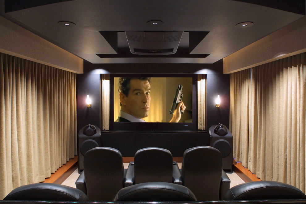 Cette photo montre une salle de cinéma chic de taille moyenne et fermée avec un mur noir, moquette et un écran de projection.