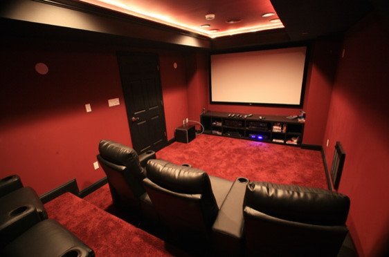 Esempio di un home theatre moderno chiuso con pareti rosse, moquette e schermo di proiezione