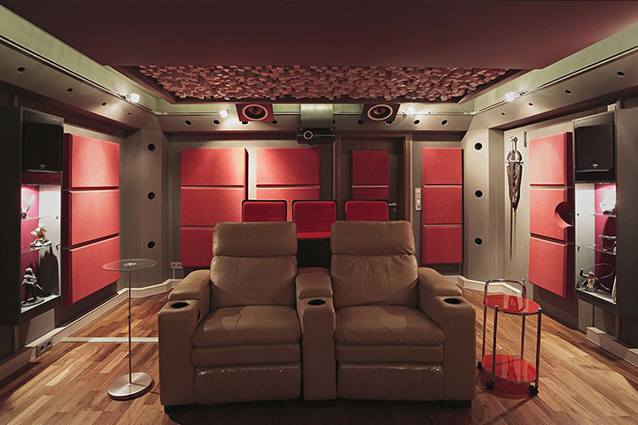 Idée de décoration pour une salle de cinéma minimaliste de taille moyenne et fermée avec un mur rouge, parquet clair, un écran de projection et un sol marron.