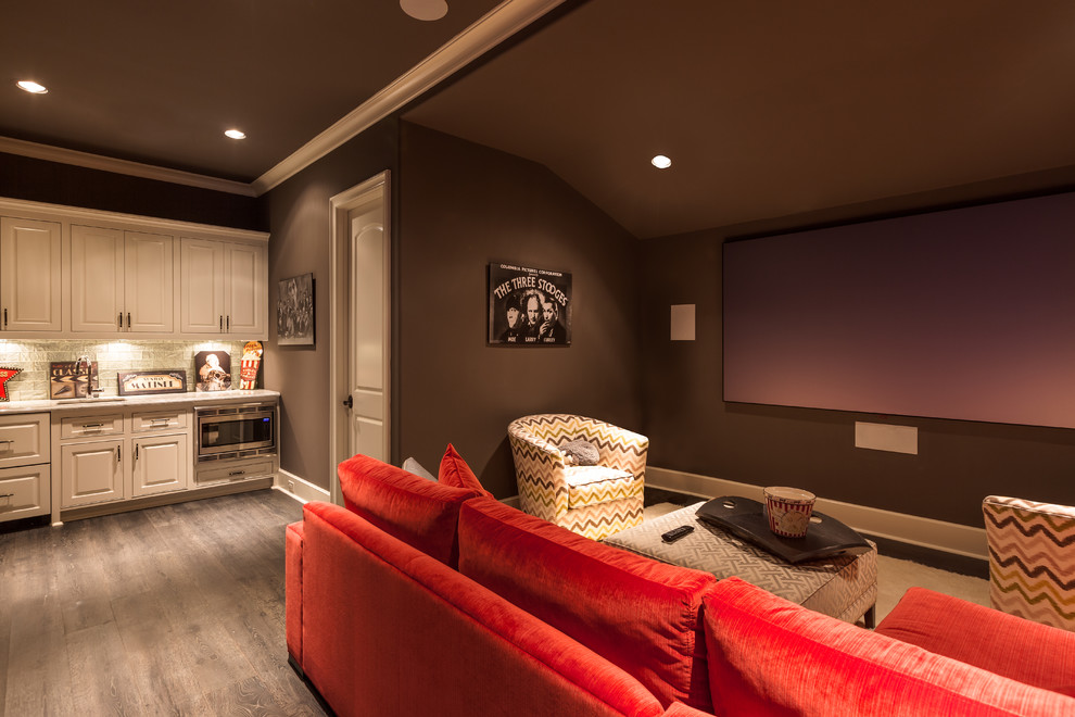 Diseño de cine en casa cerrado vintage de tamaño medio con paredes verdes, suelo de madera oscura, televisor colgado en la pared y suelo marrón