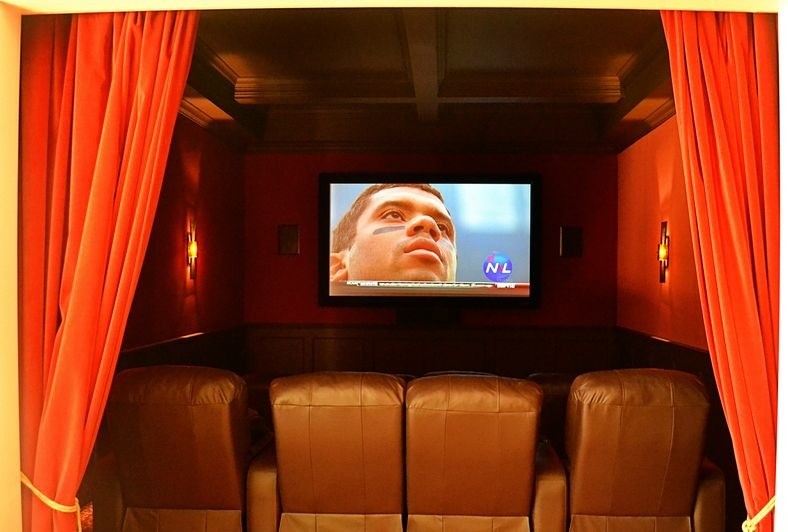 Home theater - contemporary home theater idea in New York with red walls and a wall-mounted tv