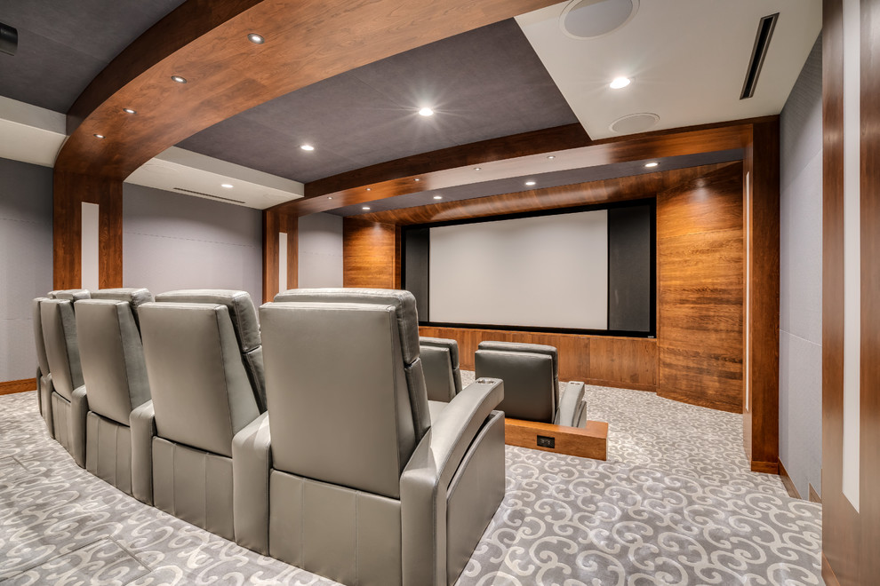 Стильный дизайн: большой изолированный домашний кинотеатр в современном стиле с серыми стенами, ковровым покрытием, проектором и серым полом - последний тренд