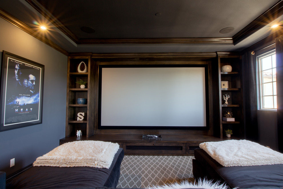 Modelo de cine en casa cerrado grande con paredes grises, moqueta, pantalla de proyección y suelo multicolor