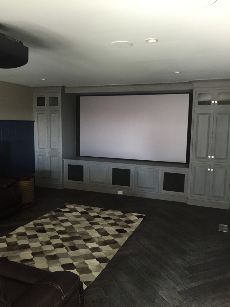 Photo of a large modern enclosed home cinema in Philadelphia with beige walls, dark hardwood flooring and a projector screen.