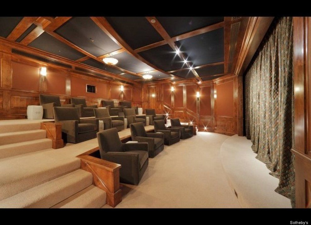 Modelo de cine en casa cerrado tradicional de tamaño medio con paredes marrones, moqueta y pantalla de proyección