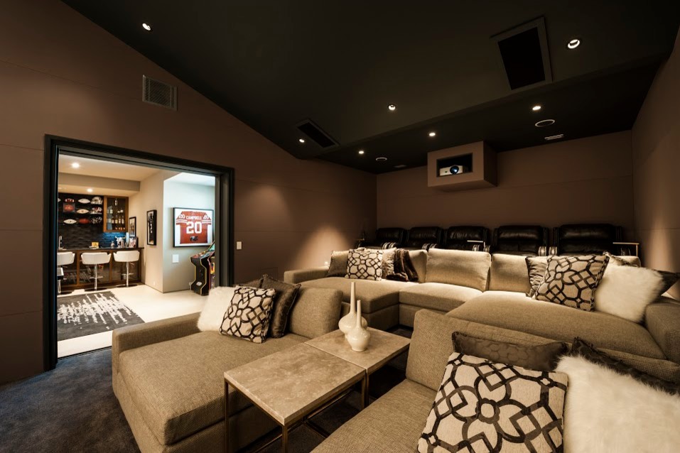 Ejemplo de cine en casa cerrado contemporáneo grande con paredes marrones, pantalla de proyección y suelo marrón