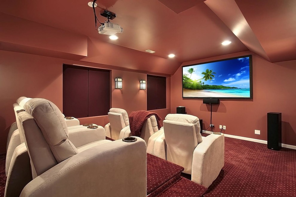 На фото: изолированный домашний кинотеатр среднего размера в стиле неоклассика (современная классика) с оранжевыми стенами, ковровым покрытием, красным полом и проектором с