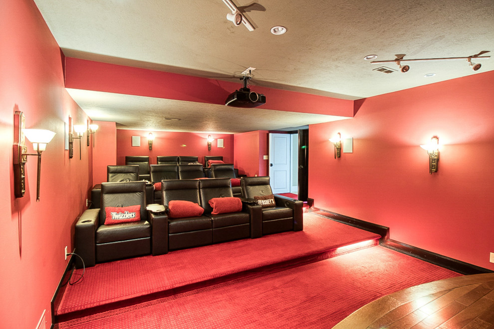 Esempio di un ampio home theatre classico chiuso con pareti rosse, moquette, schermo di proiezione e pavimento rosso