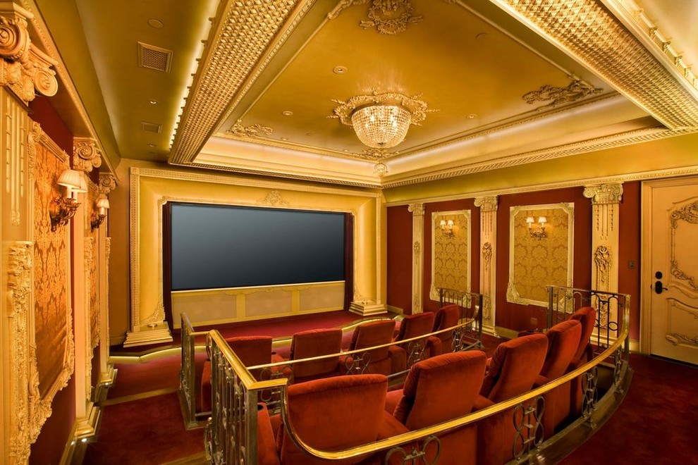 This is an example of a traditional enclosed home cinema in Los Angeles with carpet, a built-in media unit and red floors.