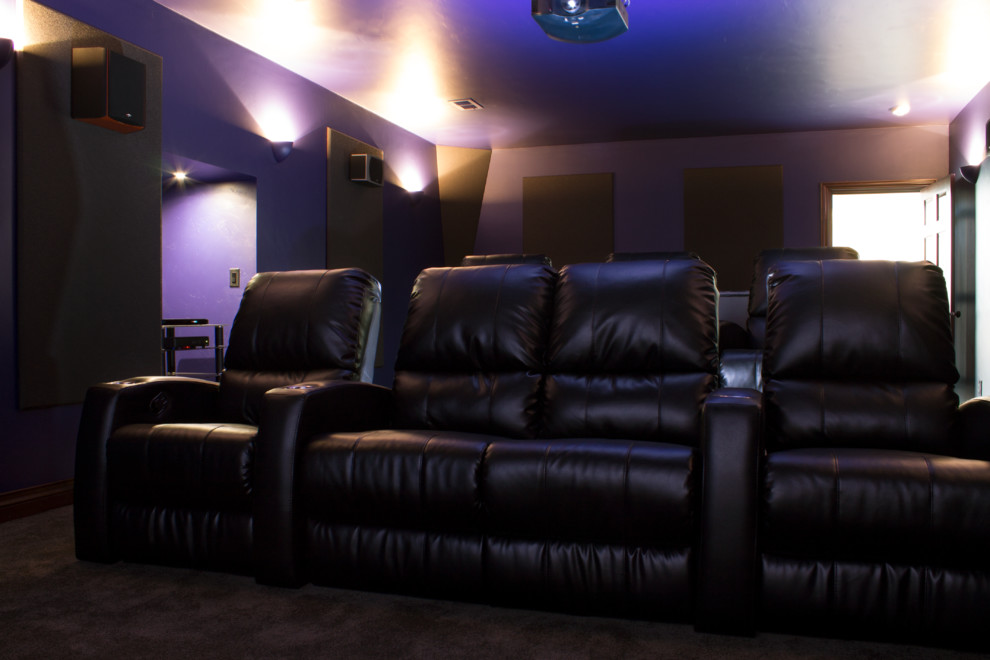 Diseño de cine en casa cerrado clásico grande con paredes púrpuras, moqueta y pantalla de proyección